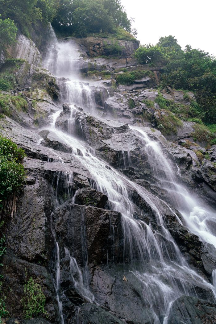 Captivating waterfall cascading down rocky cliffs surrounded by lush greenery in Turkey.